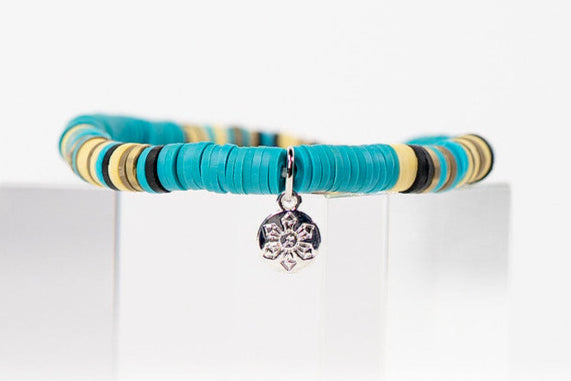 Multicolored bracelet with a silver charm on a white background
